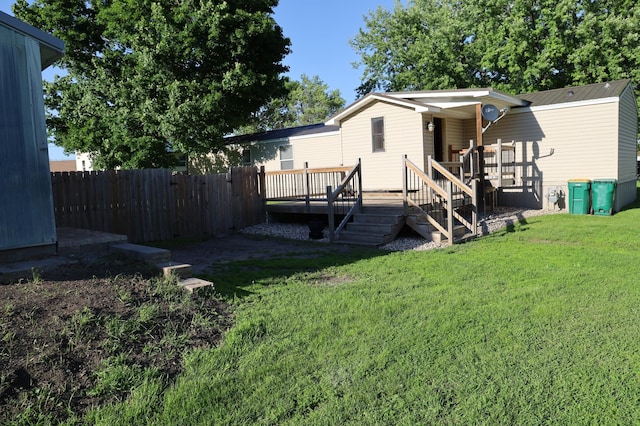 back of house featuring a lawn and a deck