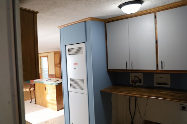 kitchen with white cabinets and a textured ceiling