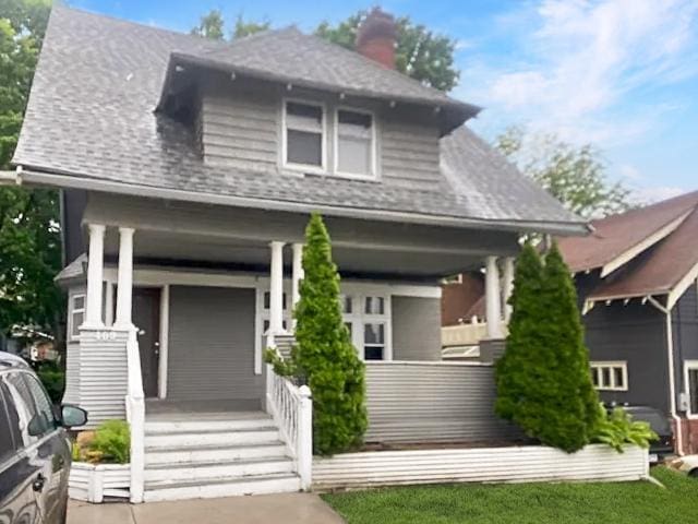 view of front of property featuring covered porch and a front yard