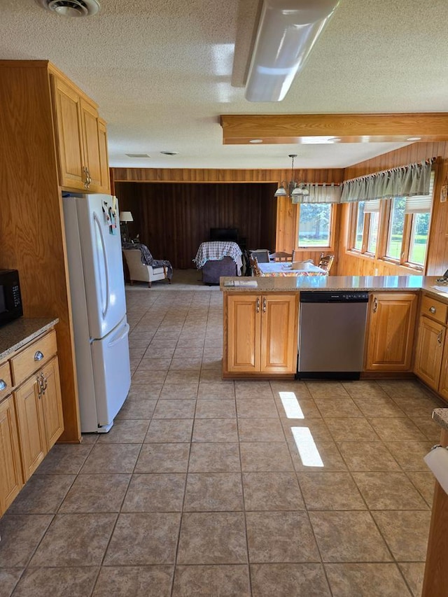 kitchen with tile patterned floors, dishwasher, white refrigerator, and decorative light fixtures