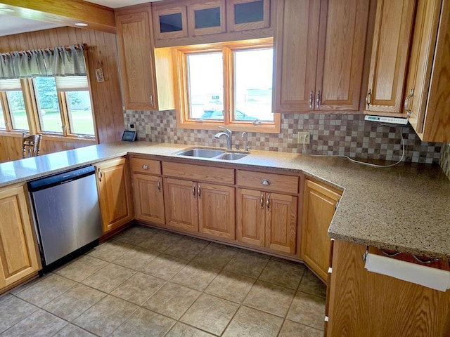 kitchen featuring backsplash, sink, light tile patterned floors, and stainless steel dishwasher