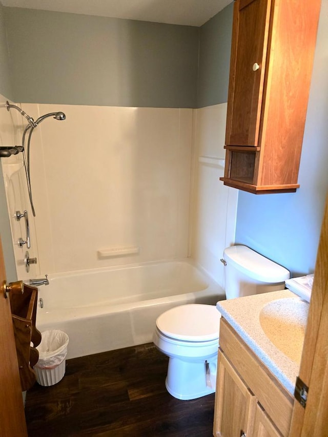 full bathroom featuring washtub / shower combination, vanity, wood-type flooring, and toilet