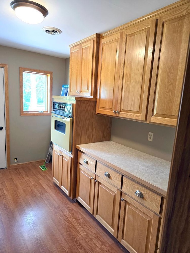 kitchen with hardwood / wood-style flooring and wall oven