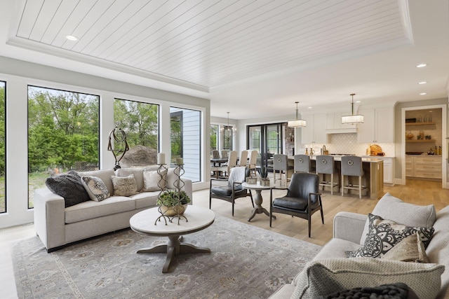 living room featuring light hardwood / wood-style flooring, a raised ceiling, and wood ceiling