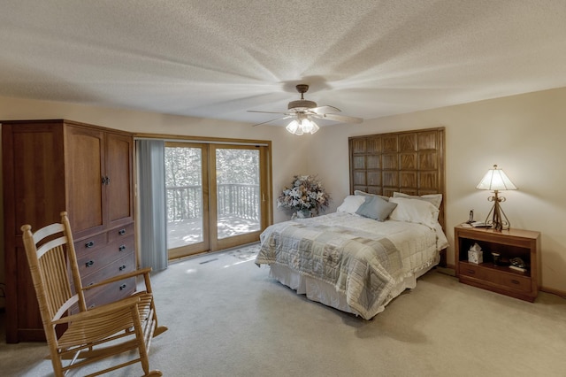 carpeted bedroom with ceiling fan, access to exterior, and a textured ceiling