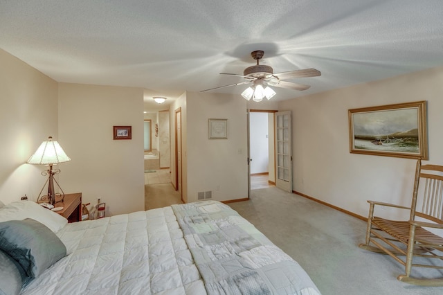 bedroom with a textured ceiling, ceiling fan, ensuite bathroom, and light carpet