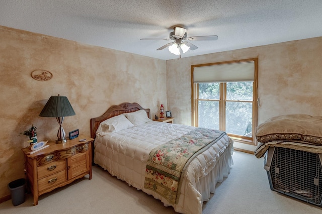 bedroom featuring a textured ceiling, light colored carpet, and ceiling fan