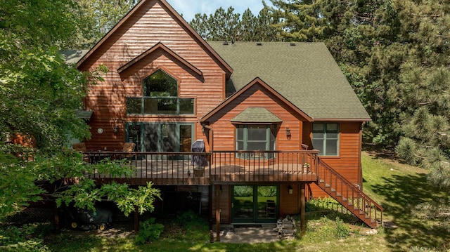 rear view of house featuring french doors, a yard, and a wooden deck