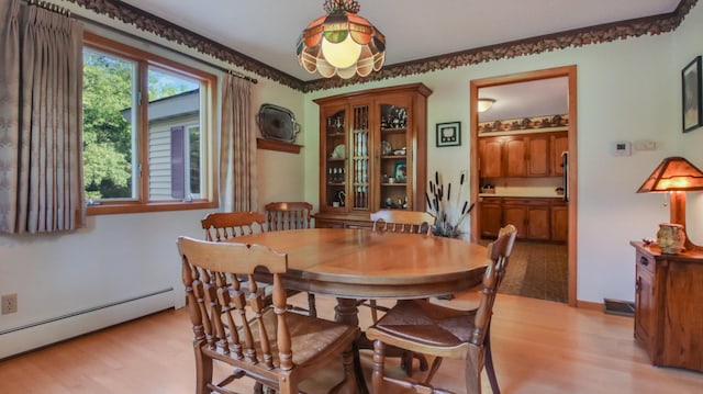 dining space with a baseboard radiator and light hardwood / wood-style floors