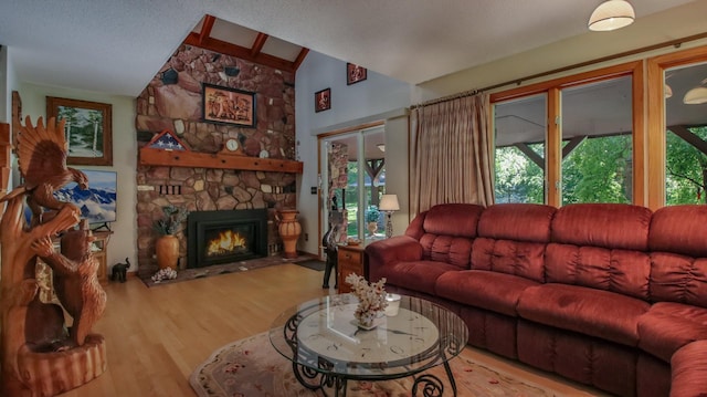 living room with vaulted ceiling with beams, hardwood / wood-style floors, and a fireplace