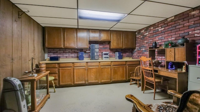 kitchen with a drop ceiling and wood walls