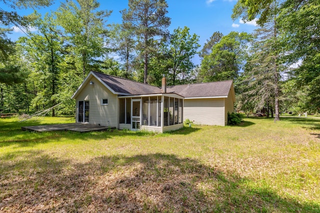 back of house with a sunroom, a wooden deck, and a yard