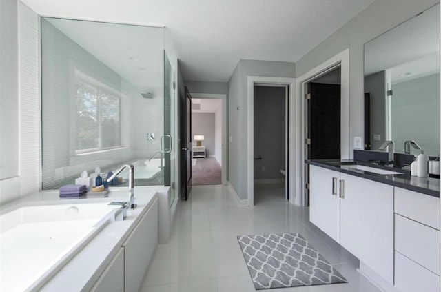 7106 Valley View Rd, Edina, MN 55439 - bathroom with vanity, tile patterned floors, a garden tub, a shower stall, and toilet