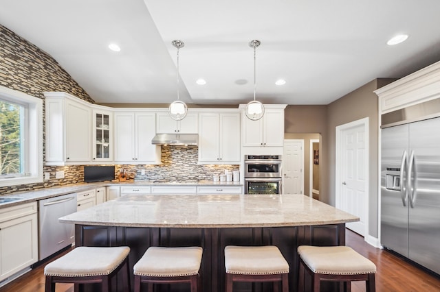 kitchen with a center island, dark hardwood / wood-style flooring, stainless steel appliances, and decorative light fixtures