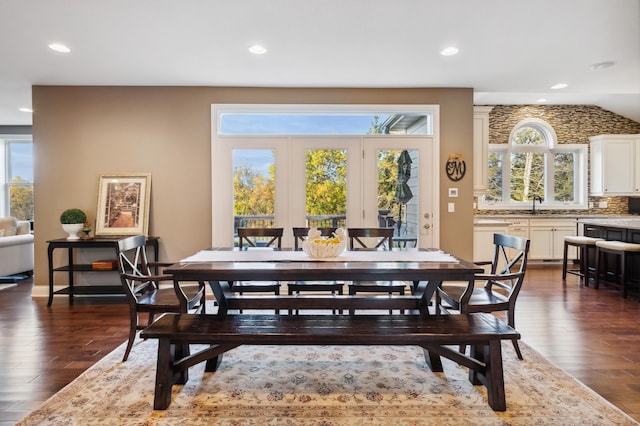 dining area featuring vaulted ceiling, dark hardwood / wood-style floors, and a wealth of natural light