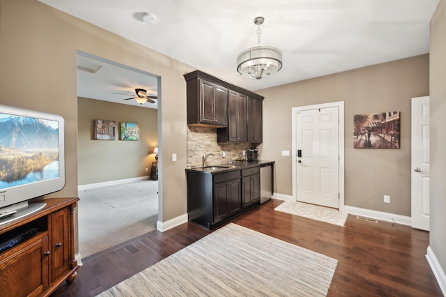 kitchen with ceiling fan with notable chandelier, dishwasher, dark wood-type flooring, and sink