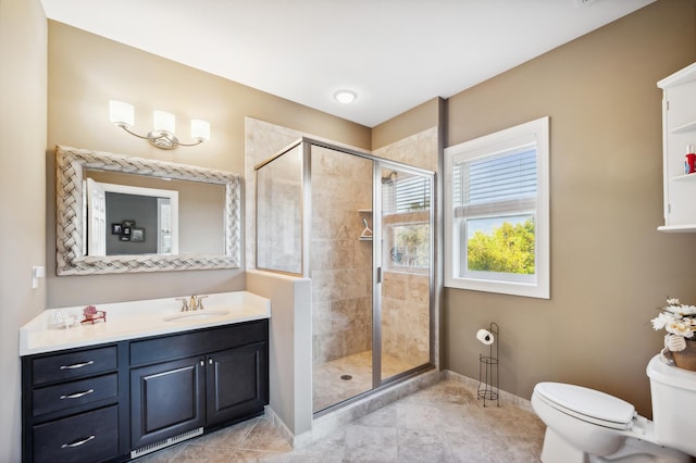 bathroom with a shower with door, toilet, vanity, and tile patterned floors