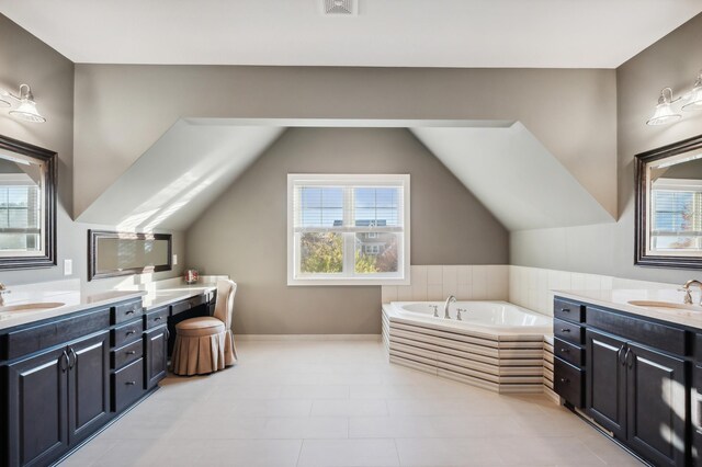 bathroom with vanity, tiled bath, lofted ceiling, and tile patterned flooring