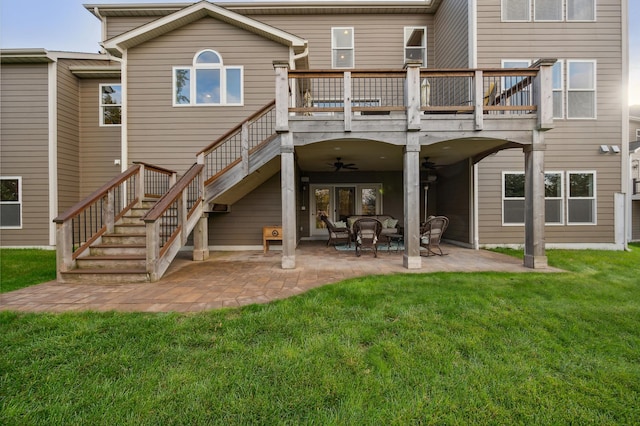 rear view of house featuring ceiling fan, a lawn, and a patio