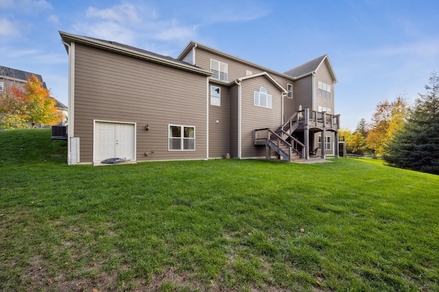 rear view of house featuring a lawn and a wooden deck