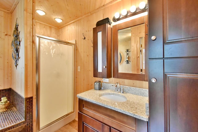 46350 Cambridge Dr, Stanchfield, MN 55080 - bathroom featuring vanity, a stall shower, wood walls, and wood finished floors