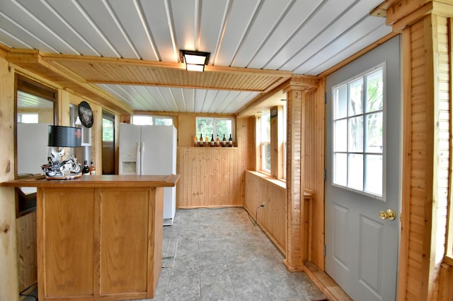 46350 Cambridge Dr, Stanchfield, MN 55080 - kitchen featuring white fridge with ice dispenser, wooden walls, plenty of natural light, and a peninsula