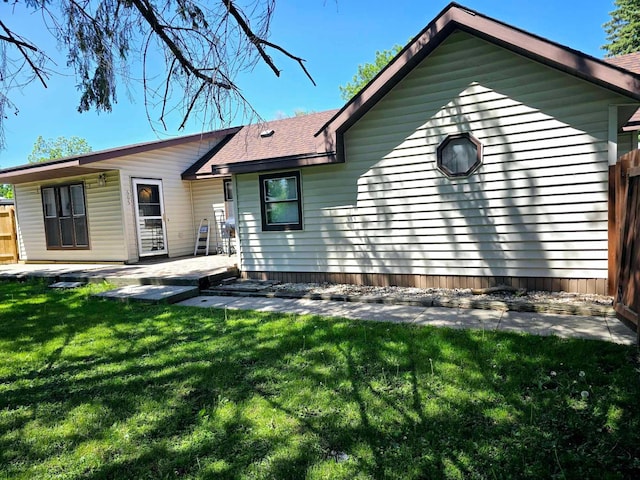 back of house featuring a lawn and a patio