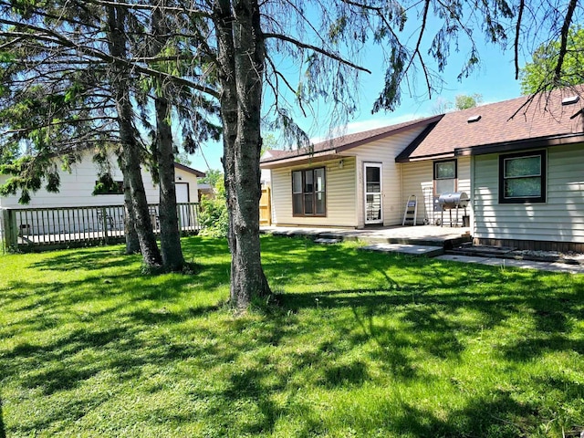 rear view of house featuring a yard and a patio