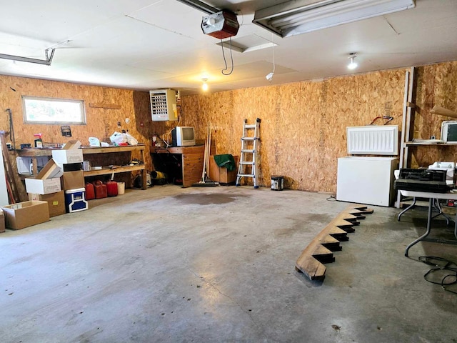 garage with a workshop area, refrigerator, and a garage door opener