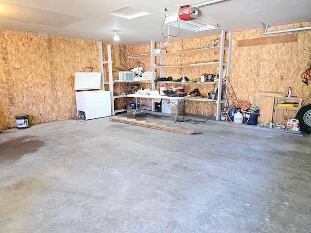 garage with a garage door opener and fridge