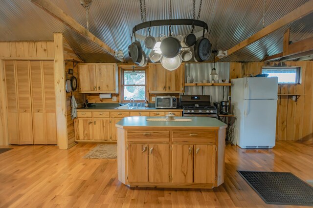 kitchen featuring stainless steel appliances, wood walls, a kitchen island, and vaulted ceiling