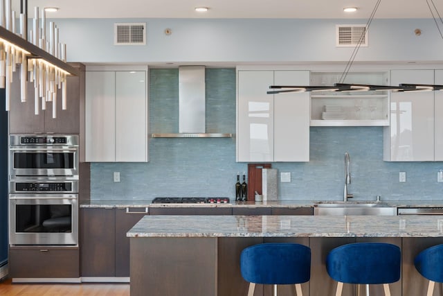 1240 2nd St Unit 1201, Minneapolis, MN 55415 - kitchen with wall chimney exhaust hood, modern cabinets, appliances with stainless steel finishes, and a breakfast bar area