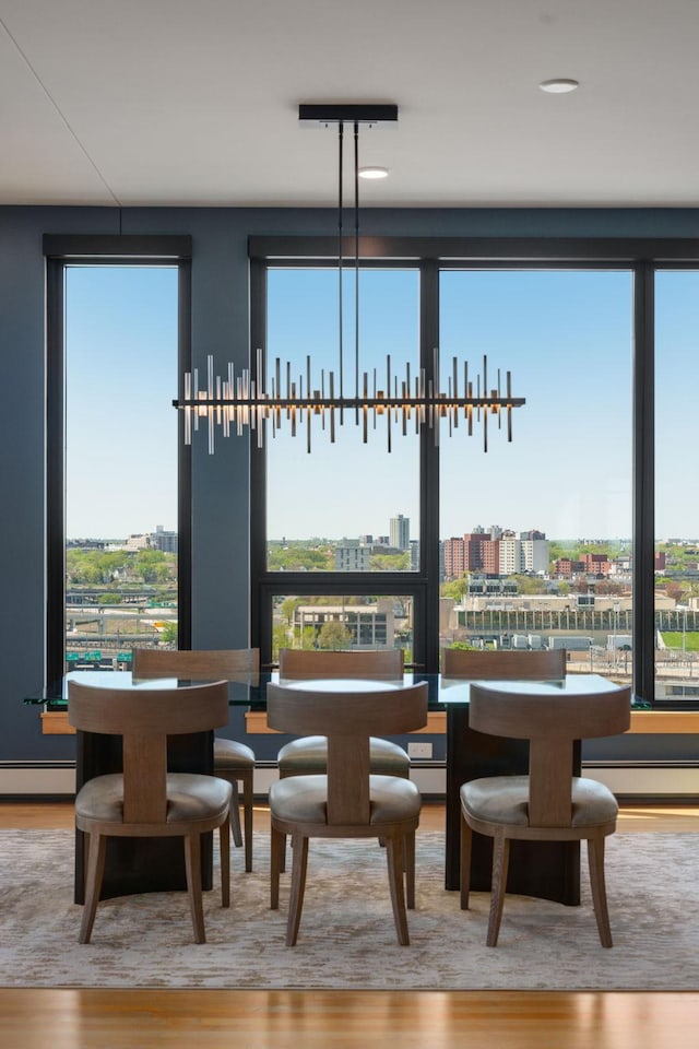 1240 2nd St Unit 1201, Minneapolis, MN 55415 - dining room featuring wood finished floors, healthy amount of natural light, a baseboard radiator, and a view of city