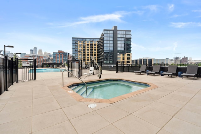 1240 2nd St Unit 1201, Minneapolis, MN 55415 - view of swimming pool with a city view, a hot tub, and a patio