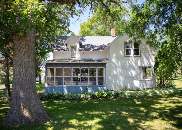 view of side of home with a yard and a sunroom