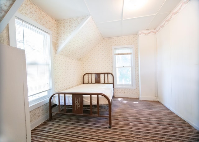 bedroom featuring dark carpet and multiple windows