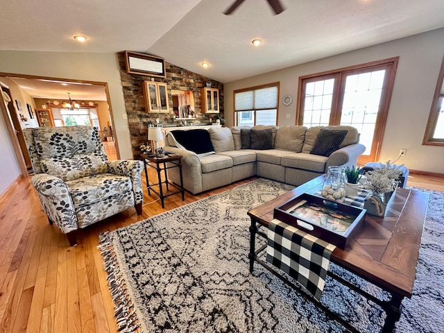 living room featuring wood-type flooring, lofted ceiling, and ceiling fan