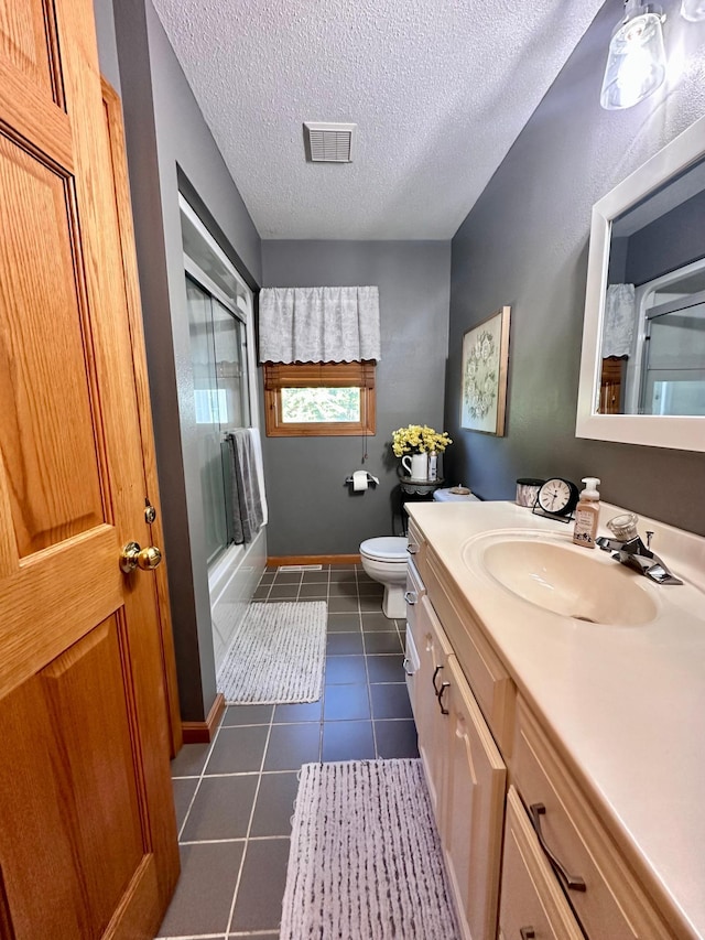 bathroom with vanity, a textured ceiling, tile patterned flooring, toilet, and an enclosed shower