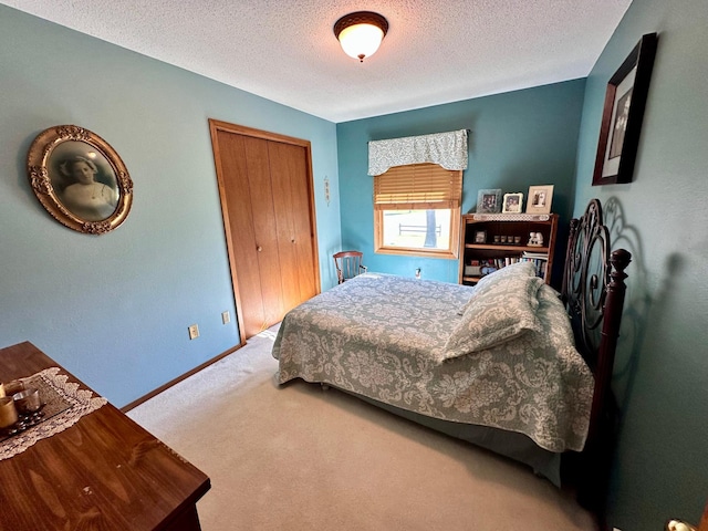 bedroom with a closet, a textured ceiling, and carpet flooring