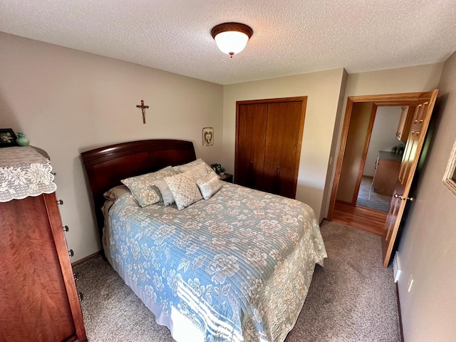 bedroom featuring a textured ceiling, a closet, and carpet flooring