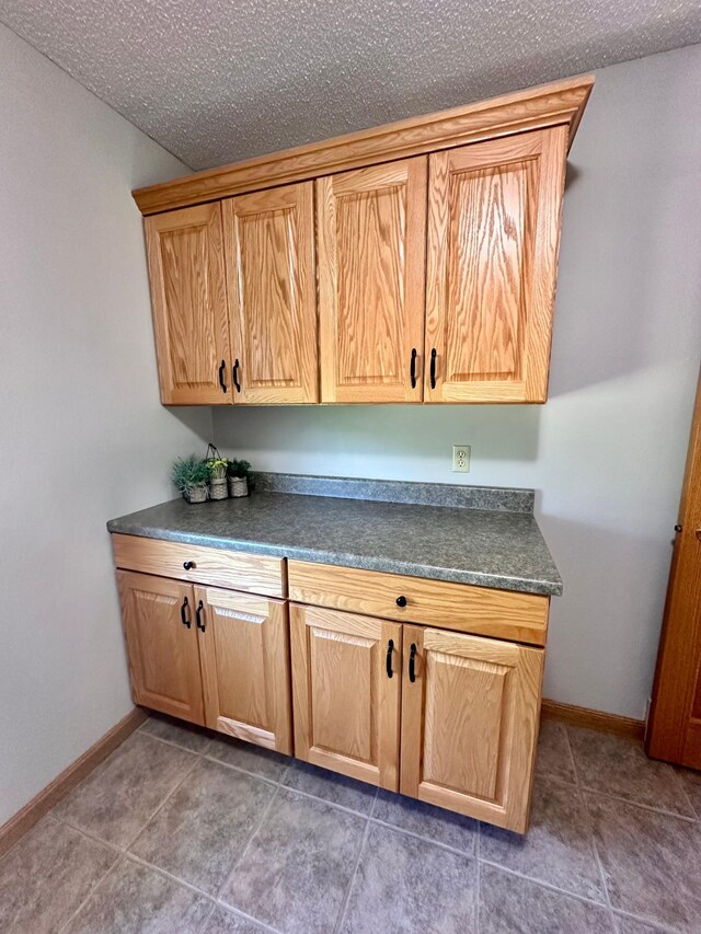 kitchen featuring dark tile patterned floors and a textured ceiling