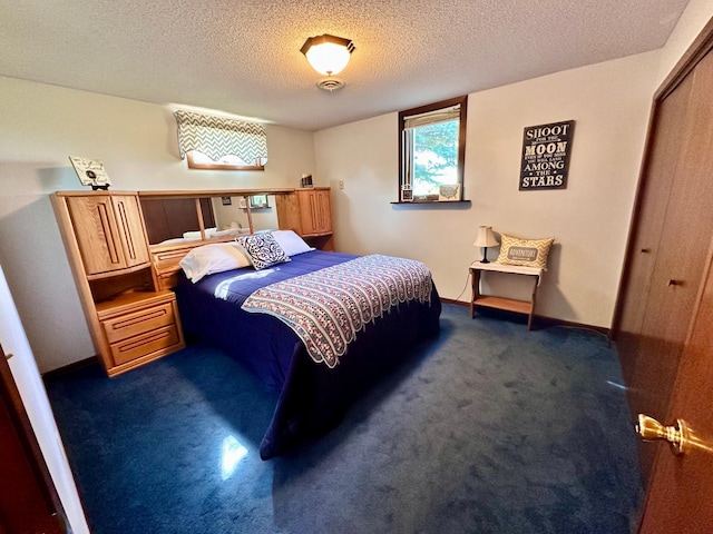 bedroom featuring dark carpet, a closet, and a textured ceiling