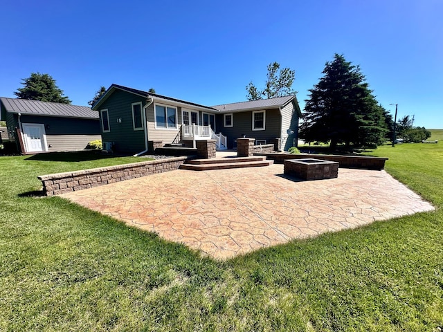 back of property featuring a lawn, a patio, a storage shed, and a fire pit