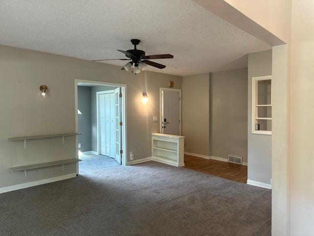 carpeted empty room featuring ceiling fan and a textured ceiling