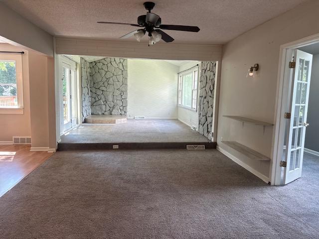 interior space featuring ceiling fan, carpet flooring, and a textured ceiling