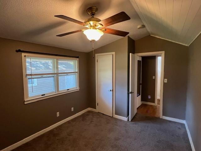 unfurnished bedroom with ceiling fan, carpet flooring, a textured ceiling, and lofted ceiling