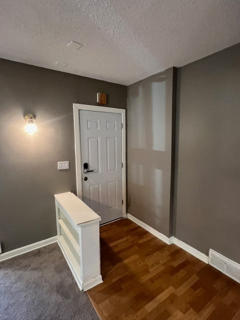 interior space featuring a textured ceiling and hardwood / wood-style flooring