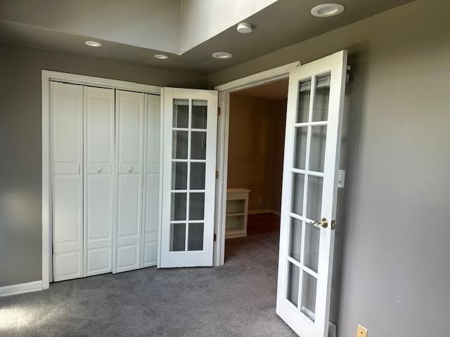 unfurnished bedroom featuring french doors, a closet, and carpet floors