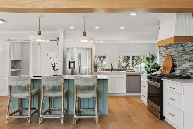 kitchen featuring pendant lighting, custom exhaust hood, white cabinetry, and stainless steel appliances