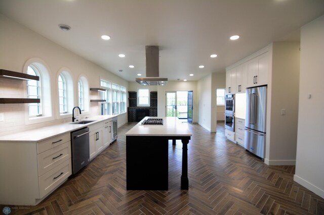 kitchen featuring white cabinets, appliances with stainless steel finishes, a center island, sink, and island range hood